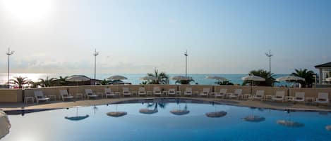 Una piscina cubierta, una piscina al aire libre de temporada, tumbonas