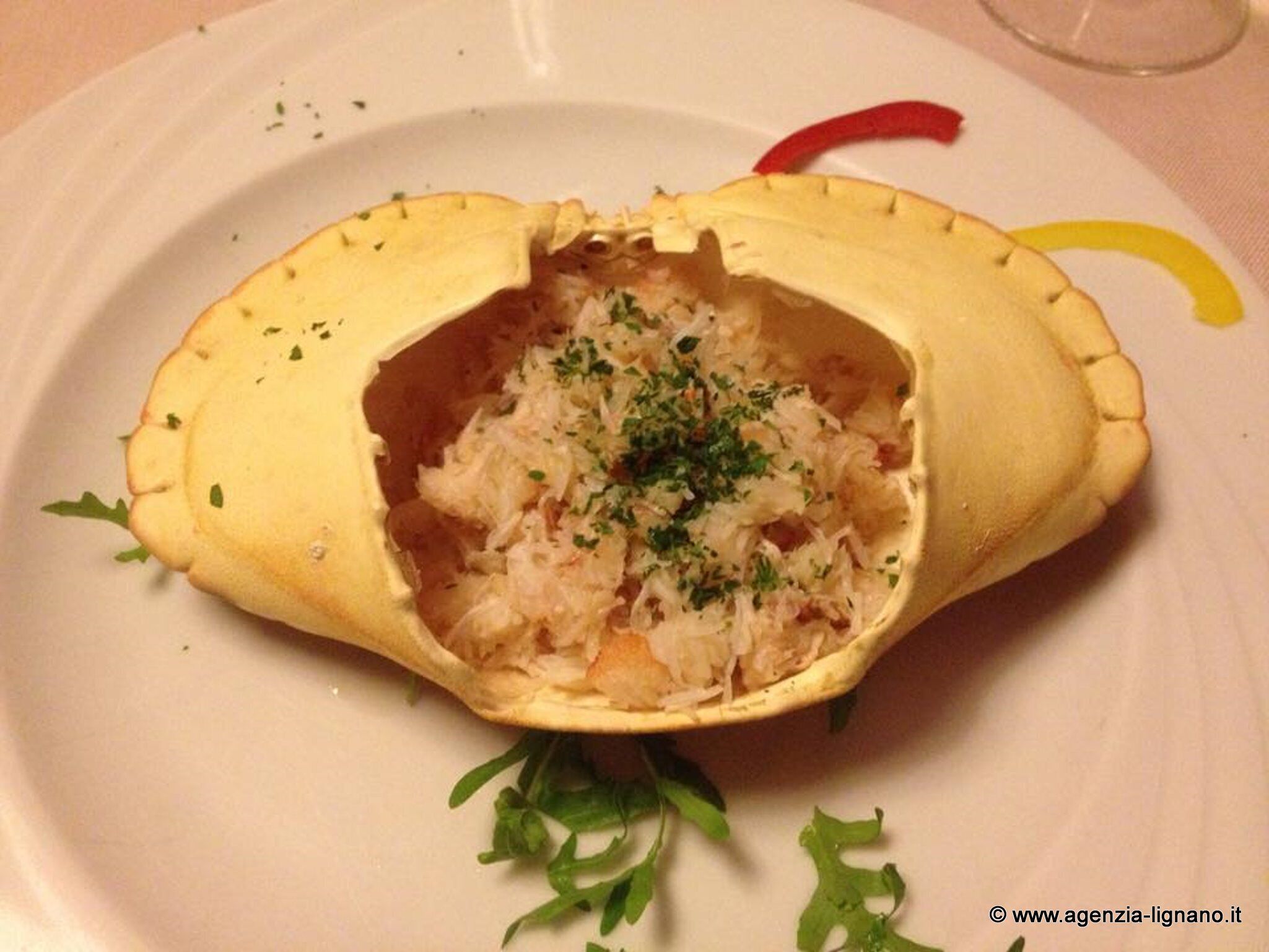 A dish with a crust, possibly a pastry, filled with a mixture of ingredients, garnished with herbs.