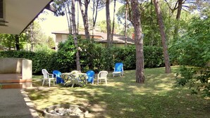 An outdoor patio area with a fire pit, several chairs, and a table.