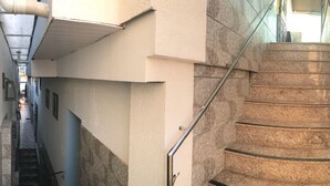 Una escalera con barandillas de metal que sube a un piso superior.