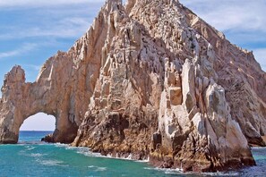 A rugged coastal rock formation with a natural archway.