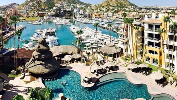 Una marina con barche, una piscina e edifici di un resort.