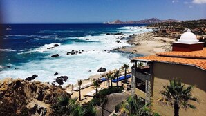 Ein Hotel an der Küste mit Blick auf den Strand, einer felsigen Küstenlinie und einer weißen Kuppel.
