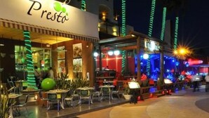 A restaurant named "Presto" with outdoor seating and illuminated columns. - Special Offer, Unbeatable Location - 2BR Suite (Cabo San Lucas)