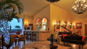 A spacious lobby with a bar area, seating arrangements, and a piano. - Special Offer, Unbeatable Location - 2BR Suite (Cabo San Lucas)