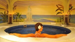 A person relaxing in a hot tub with a mural of a beach scene in the background. - Special Offer, Unbeatable Location - 2BR Suite (Cabo San Lucas)