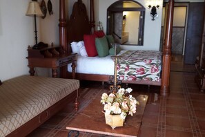 Un dormitorio con cama de madera, mesita de noche, lámpara y espejo.