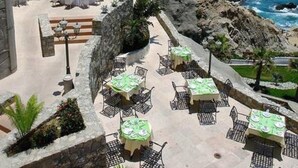 An outdoor dining area with tables and chairs, overlooking the ocean. - Huge 3BR Private Villa - Cabo San Lucas (Cabo San Lucas)