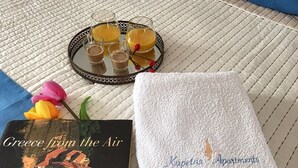 Una bandeja con bebidas y un libro titulado 'Greece from the Air' sobre una superficie texturizada.