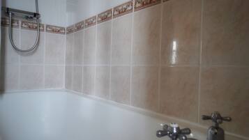 Un baño con bañera, ducha e inodoro.