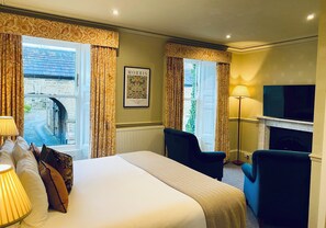 A hotel room with a bed, two chairs, a TV, and a fireplace. - Middle House (Leyburn)