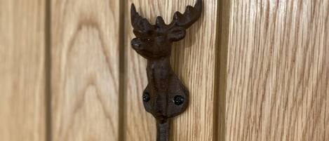A wooden door with a metal door knocker shaped like a seahorse.