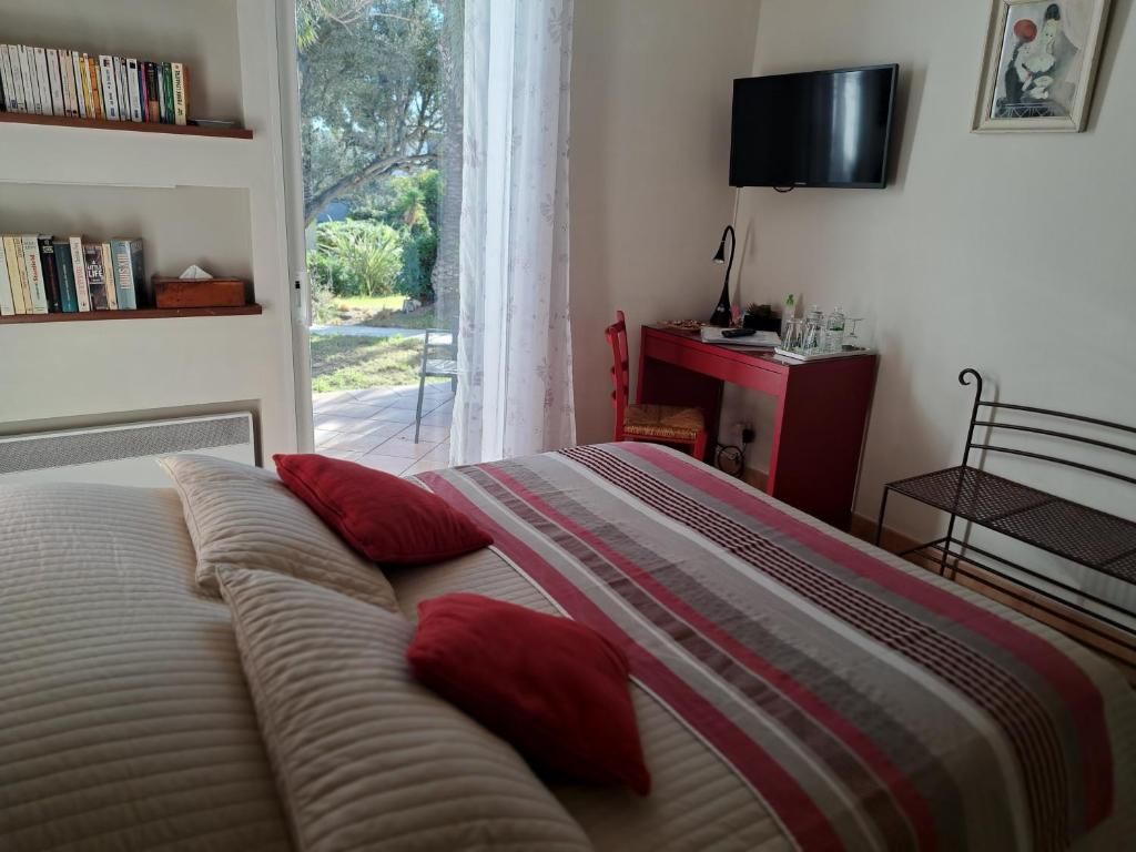 Une chambre à coucher avec un lit, un bureau, une télévision et une bibliothèque.