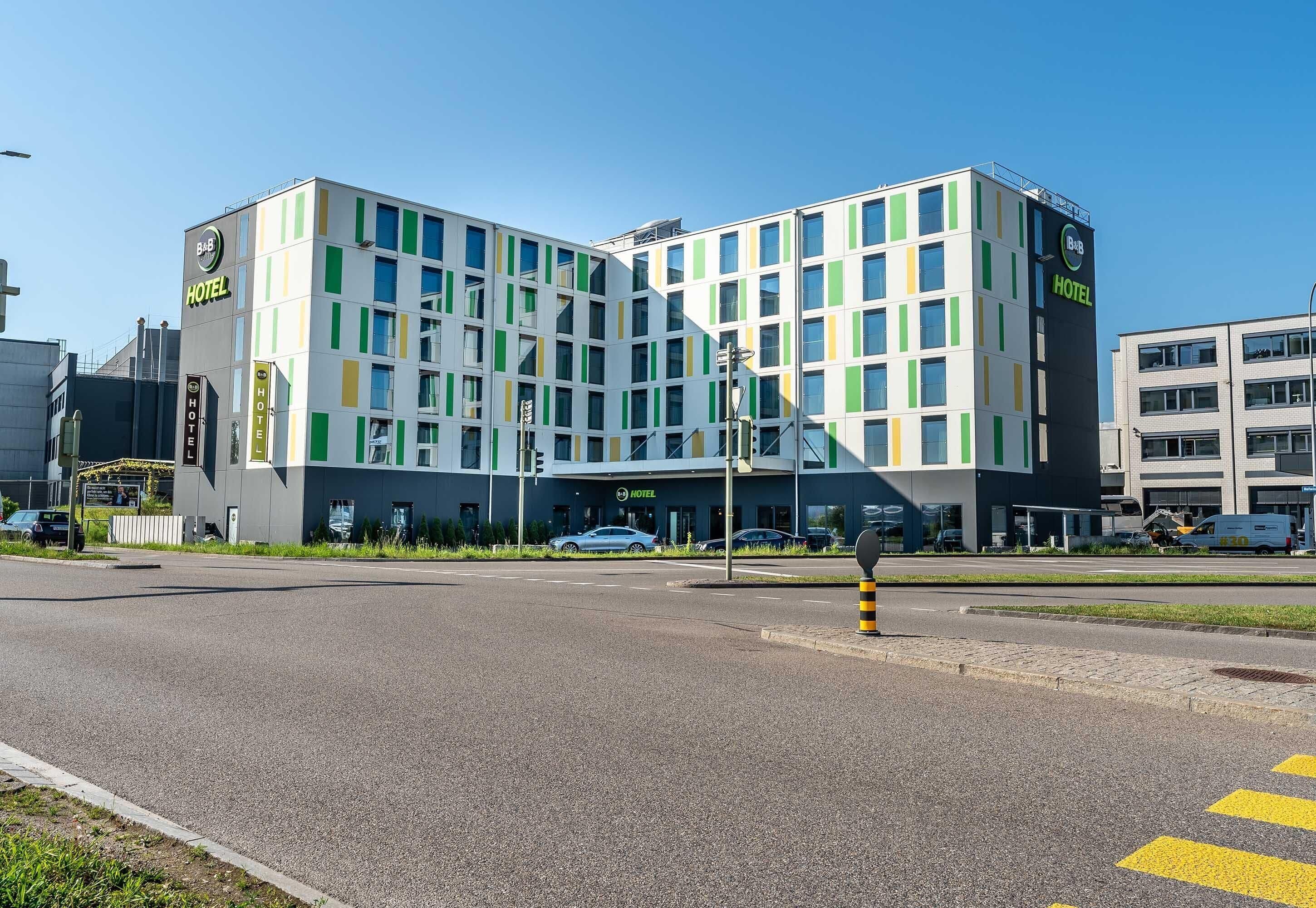 A modern hotel with a multi-story structure, a prominent entrance, and a clear sky.