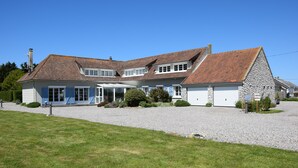 A two-story house with a stone facade, a large garage, and a covered patio area. - BAIE EN BULLES - Les Portes du Hable (Cayeux-sur-Mer)