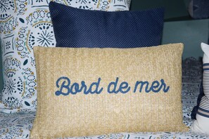 A bed with patterned bedding and a pillow with embroidered text. - BAIE EN BULLES - Les Portes du Hable (Cayeux-sur-Mer)