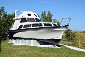 A stationary boat with a cabin, deck, and a small figurehead. - BAIE EN BULLES - Les Portes du Hable (Cayeux-sur-Mer)