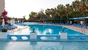A large outdoor swimming pool with blue water, surrounded by lounge chairs and umbrellas. - Bieno Venus Hotel (Manavgat)