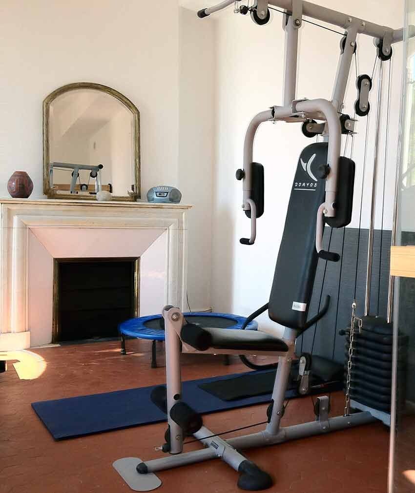 Une salle de sport à domicile équipée d’une barre de traction, d’un banc et d’un miroir.
