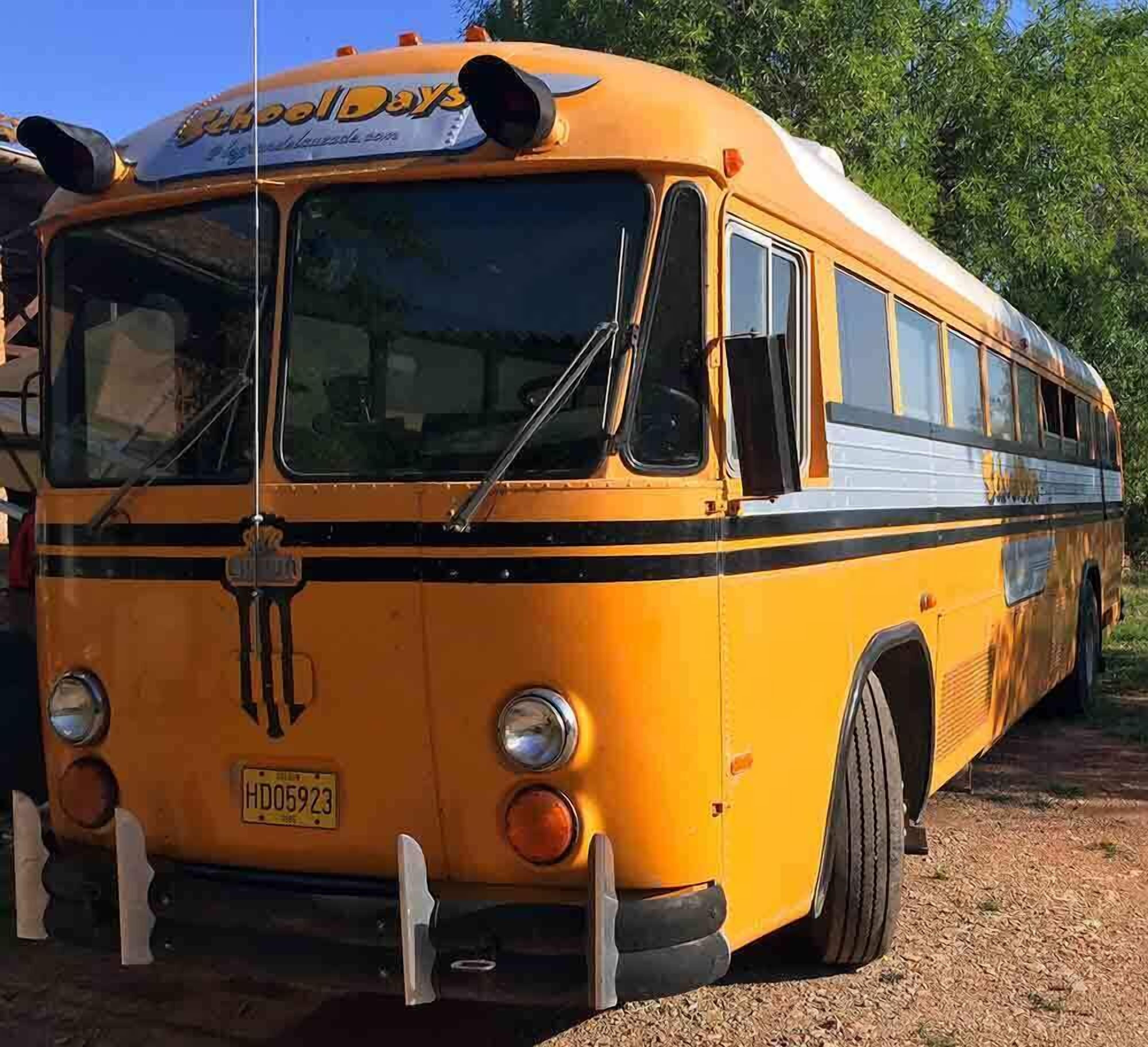 A yellow school bus with the name "Holiday Days" on the front, parked outdoors.