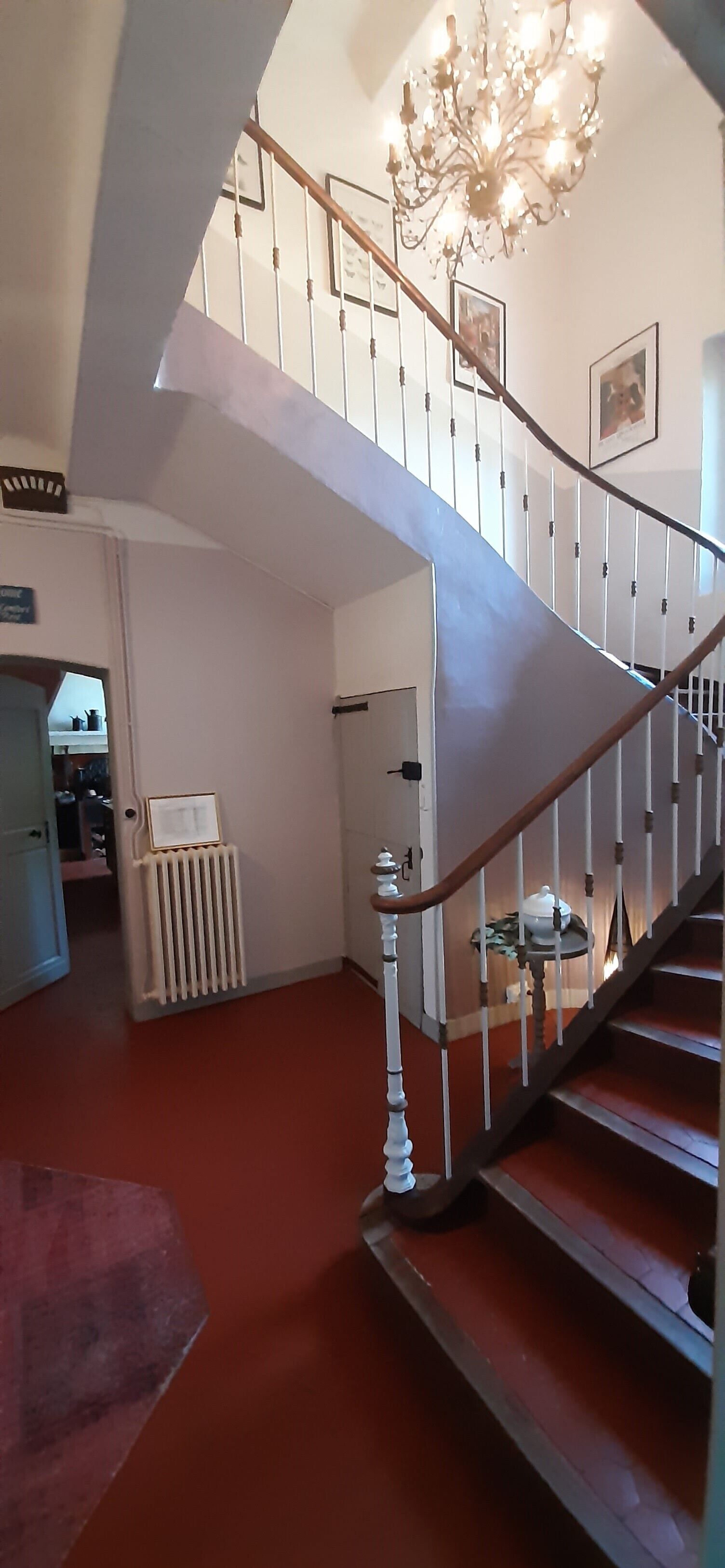 A staircase with a wooden handrail and white balusters, leading to an upper floor.