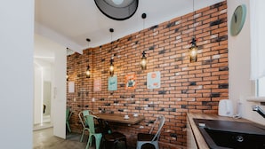 Eine moderne Küche mit Backsteinwand, hängenden Pendelleuchten und einer Holz Arbeitsplatte.