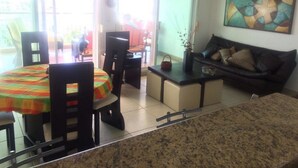 Un coin repas avec une table et des chaises, un canapé et un tableau accroché au mur.