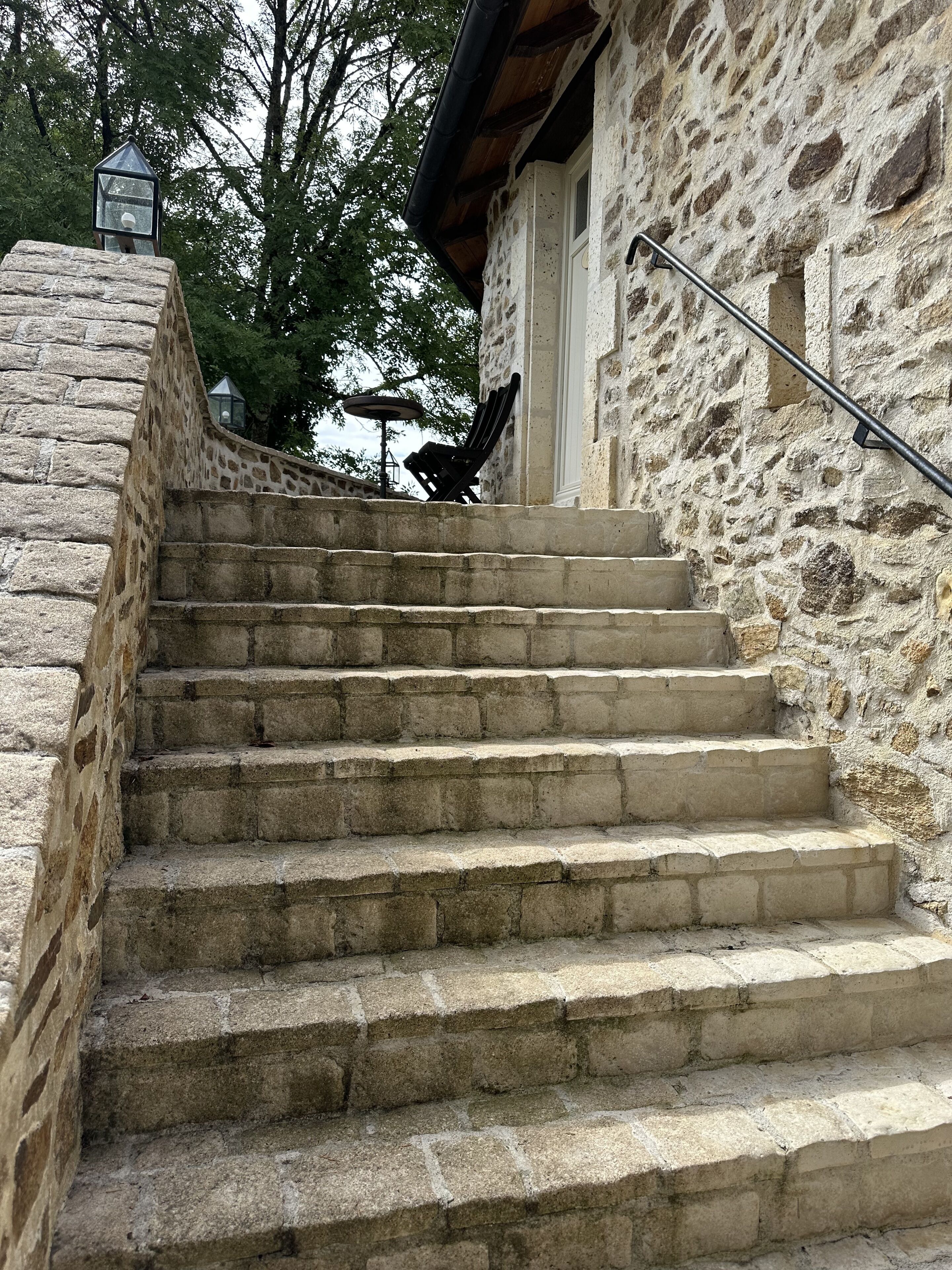 Uma escadaria de pedra que leva a um edifício com fachada de pedra.