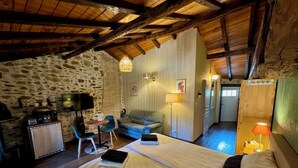 Una habitación acogedora con una cama, un escritorio, una silla y un televisor.