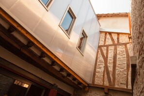 A building with a modern facade, exposed wooden beams, and a stone wall. - Impasse du Boeuf (Lavaur)