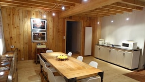 A wooden-paneled room with a dining table, chairs, a kitchen area, and a framed picture on the wall. - Impasse du Boeuf (Lavaur)