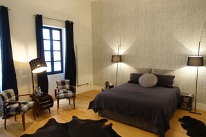 A bedroom with a large bed, two chairs, a table, and two floor lamps. - Impasse du Boeuf (Lavaur)
