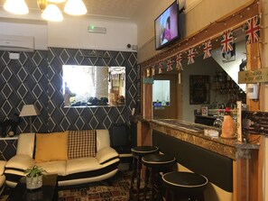 A bar area with a television, British flags, and a 'No Children in Bar Area' sign. - Glenheath Hotel (Blackpool)