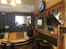 Een barruimte met een televisie, Britse vlaggen en een bord met de tekst 'Geen kinderen in de bar'.