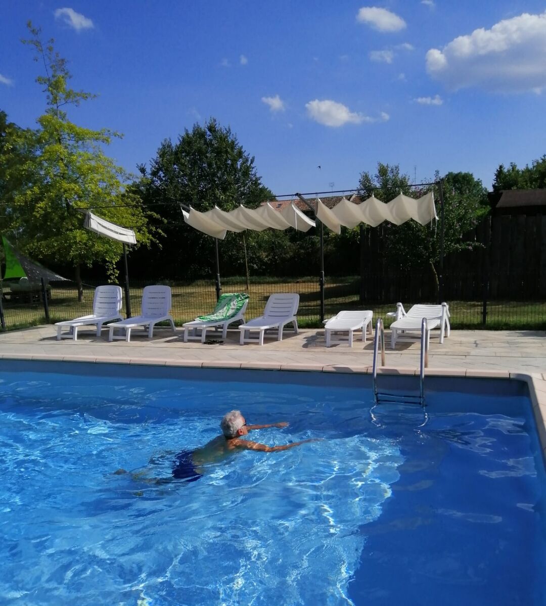 A swimming pool with lounge chairs and umbrellas.