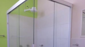 A bathroom with a glass shower enclosure, a toilet, and a sink. - Casa Villa R (Mazatlán)