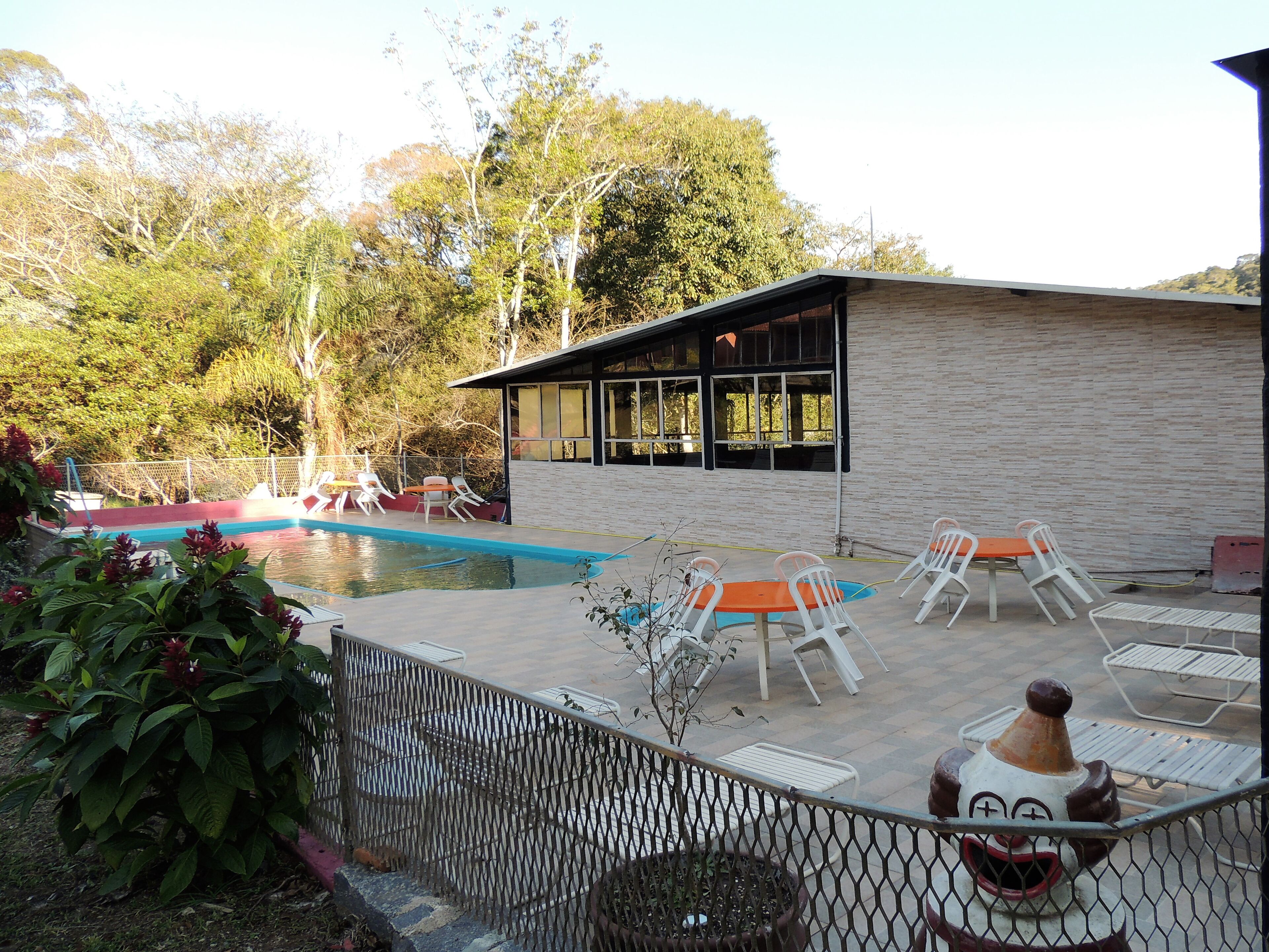 Un espace piscine avec des chaises longues et un bâtiment doté de grandes fenêtres.