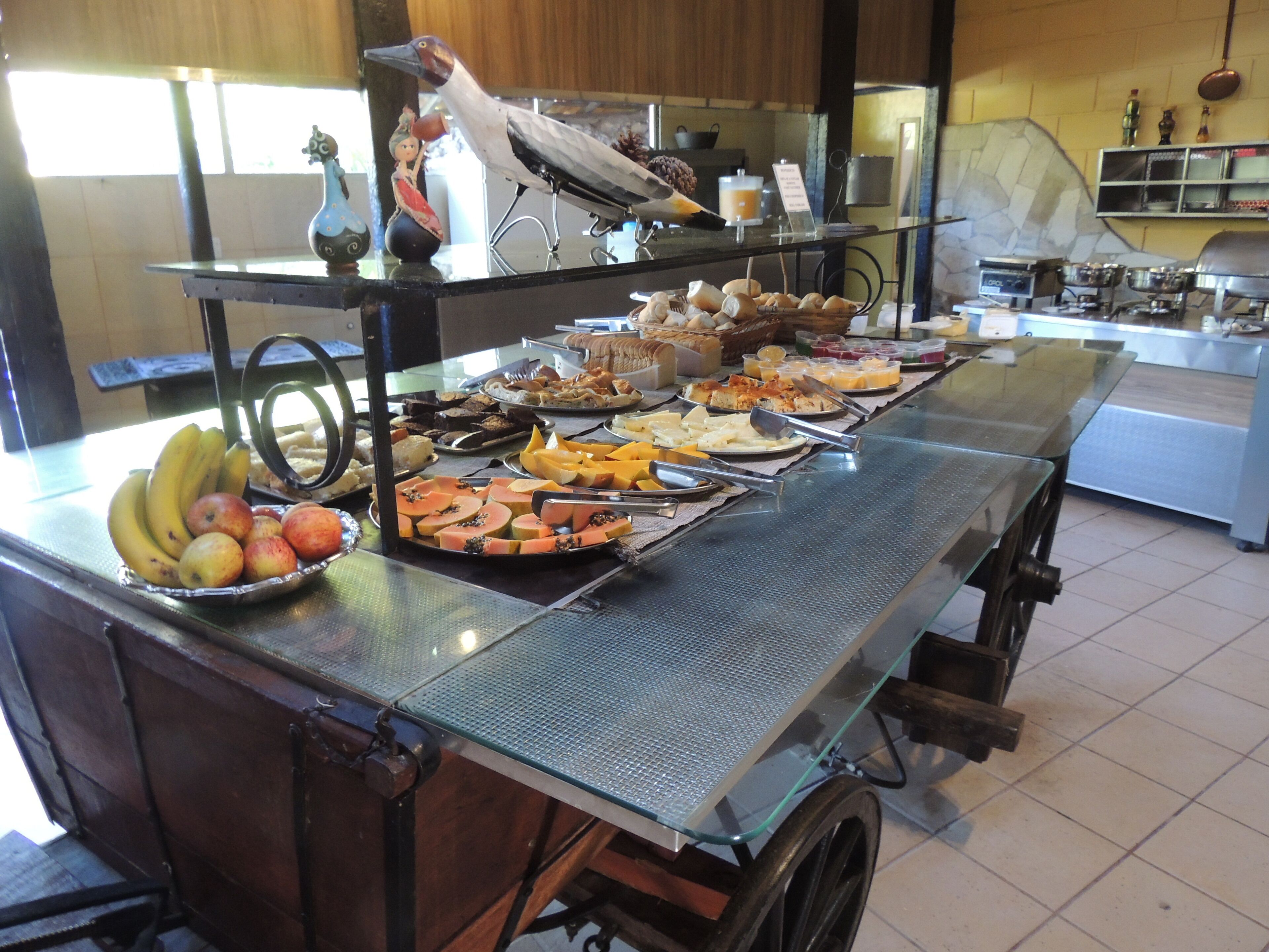 Un buffet con diversi cibi e un uccello decorativo su un piedistallo.
