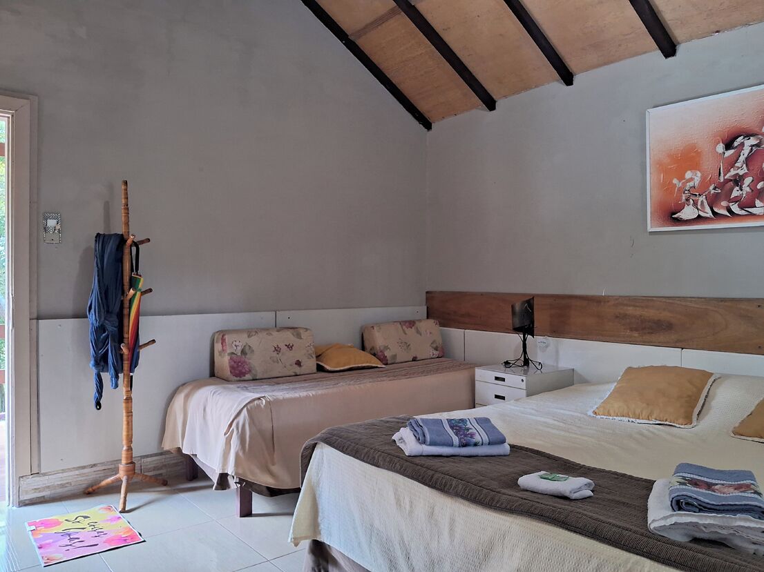 A bedroom with a bed, bedside table, lamp, and a painting on the wall.