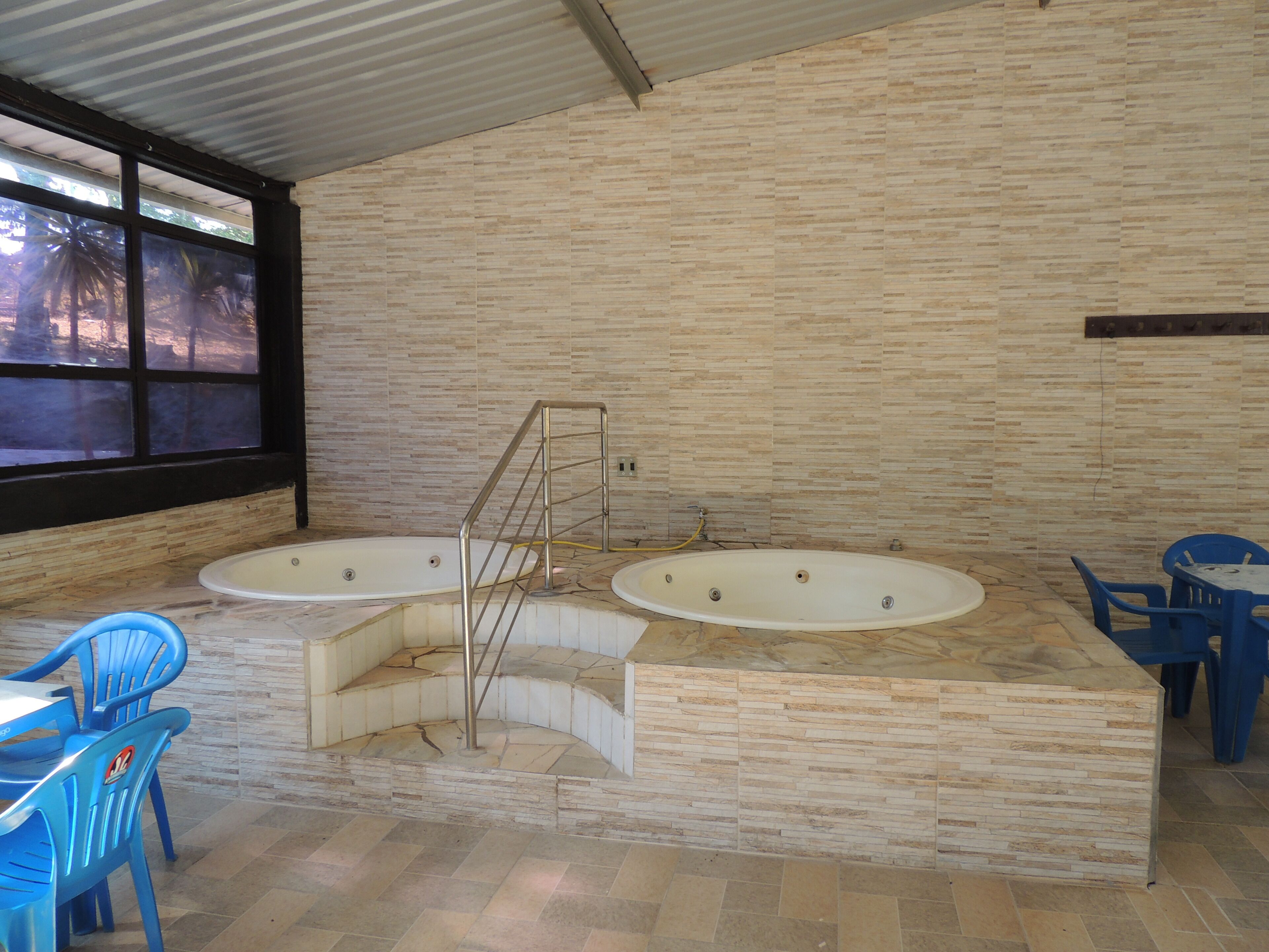 Un área de spa con dos jacuzzis, una escalera y sillas azules.
