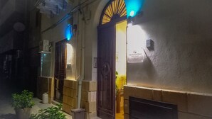 A building entrance with a wooden door and a sign above it. - Palazzo Cutelli LGBTQ House (Palermo)