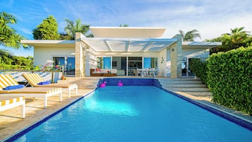 Relax by the outdoor pool surrounded by lush greenery and a well-maintained garden.