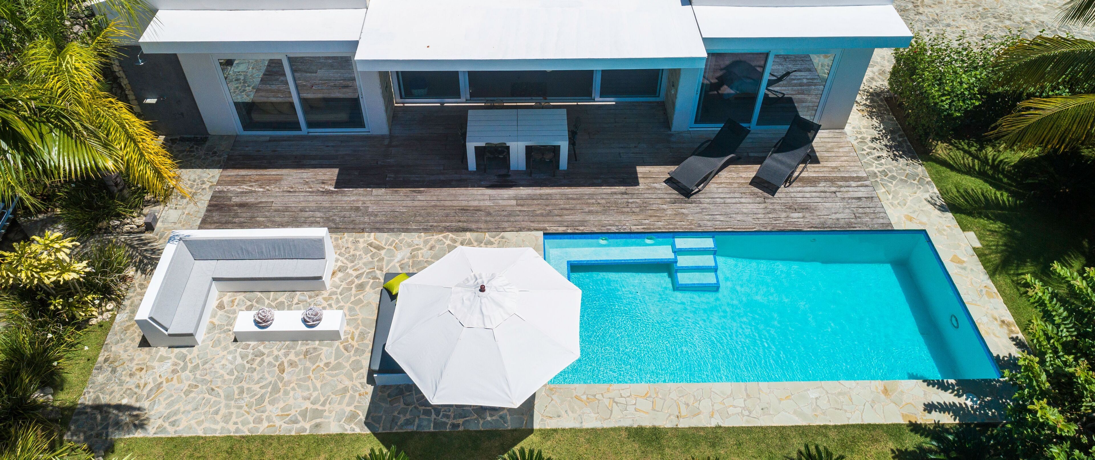 Een modern huis met zwembad, terras en een dek.