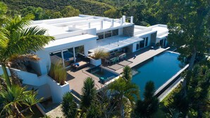 A modern house with a swimming pool, surrounded by lush greenery. - Villas Agua Dulce (Cabarete)
