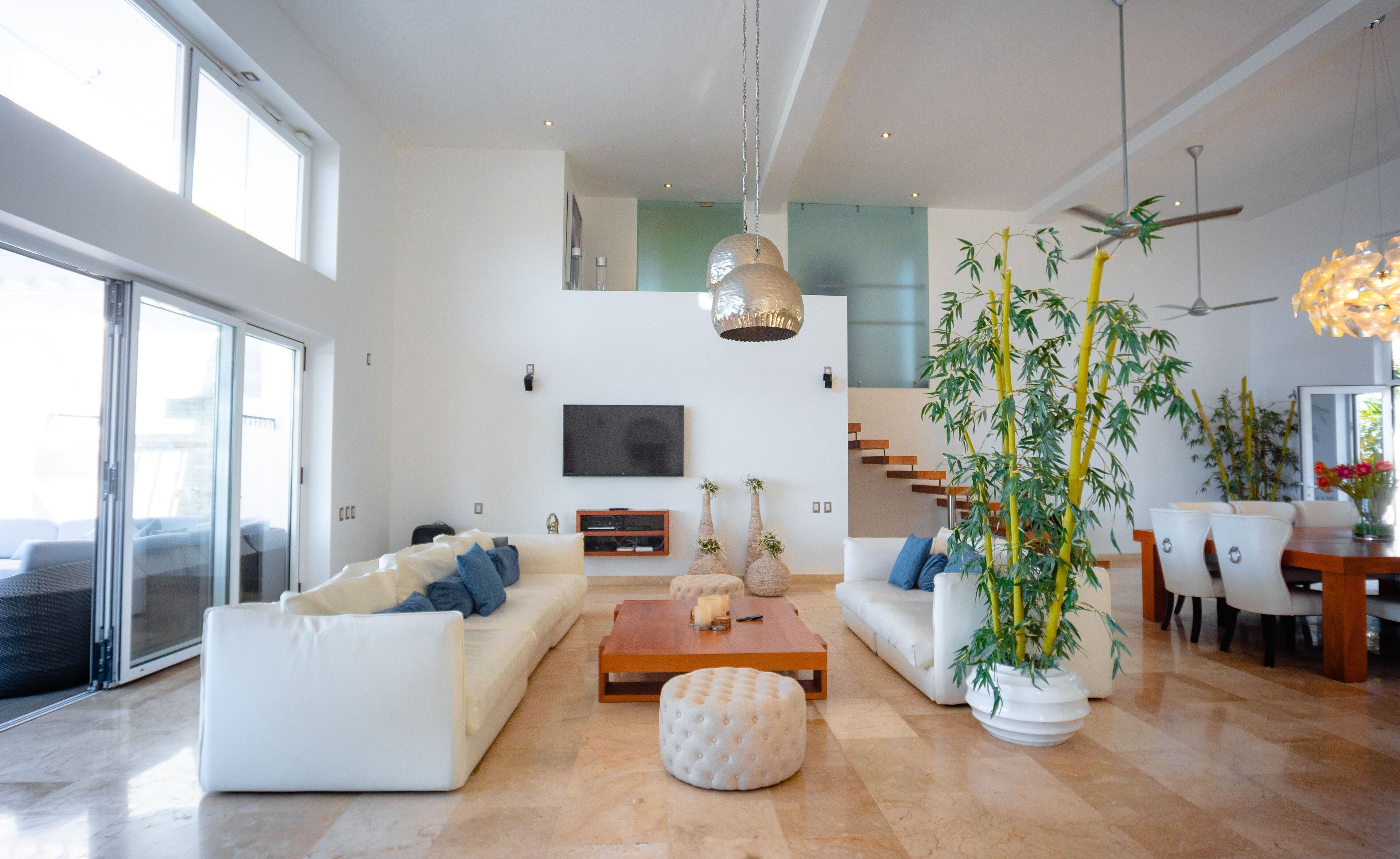 Un salón amplio con un sofá grande, una mesa de centro y una planta en maceta.