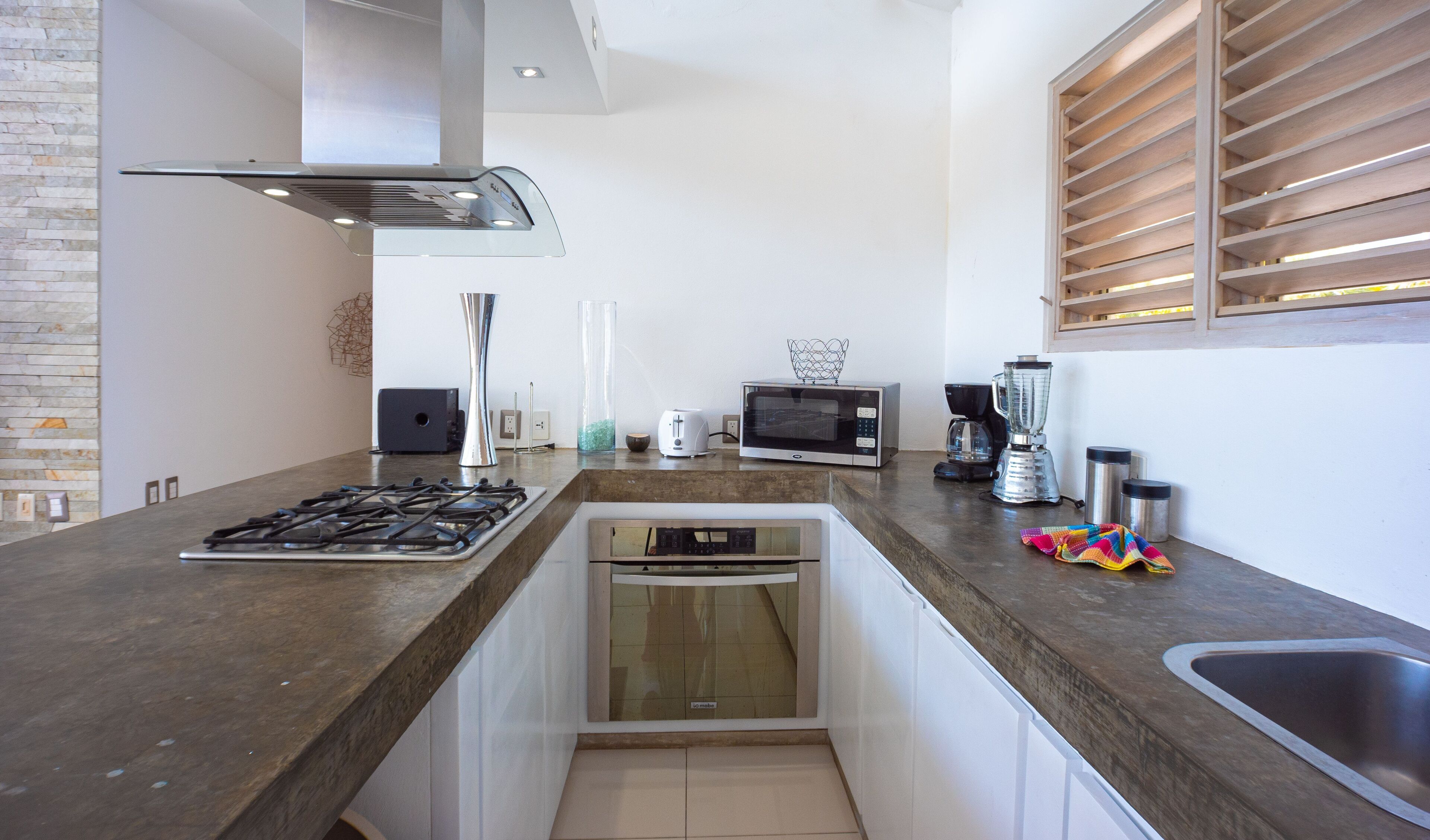 A modern kitchen with a gas stove, microwave, coffee maker, and dishwasher.