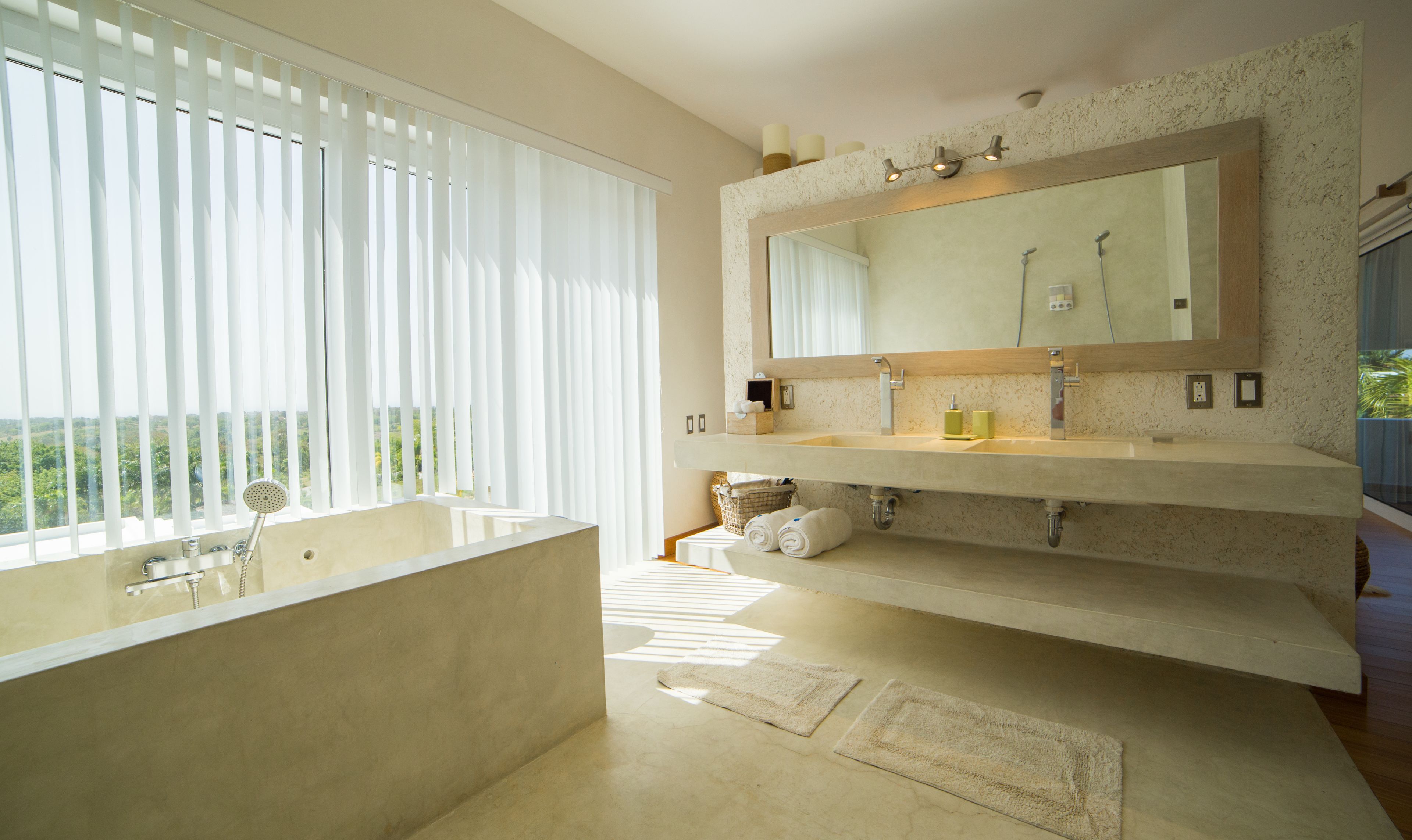 Une salle de bain moderne avec une grande baignoire, un meuble-lavabo double et un grand miroir.