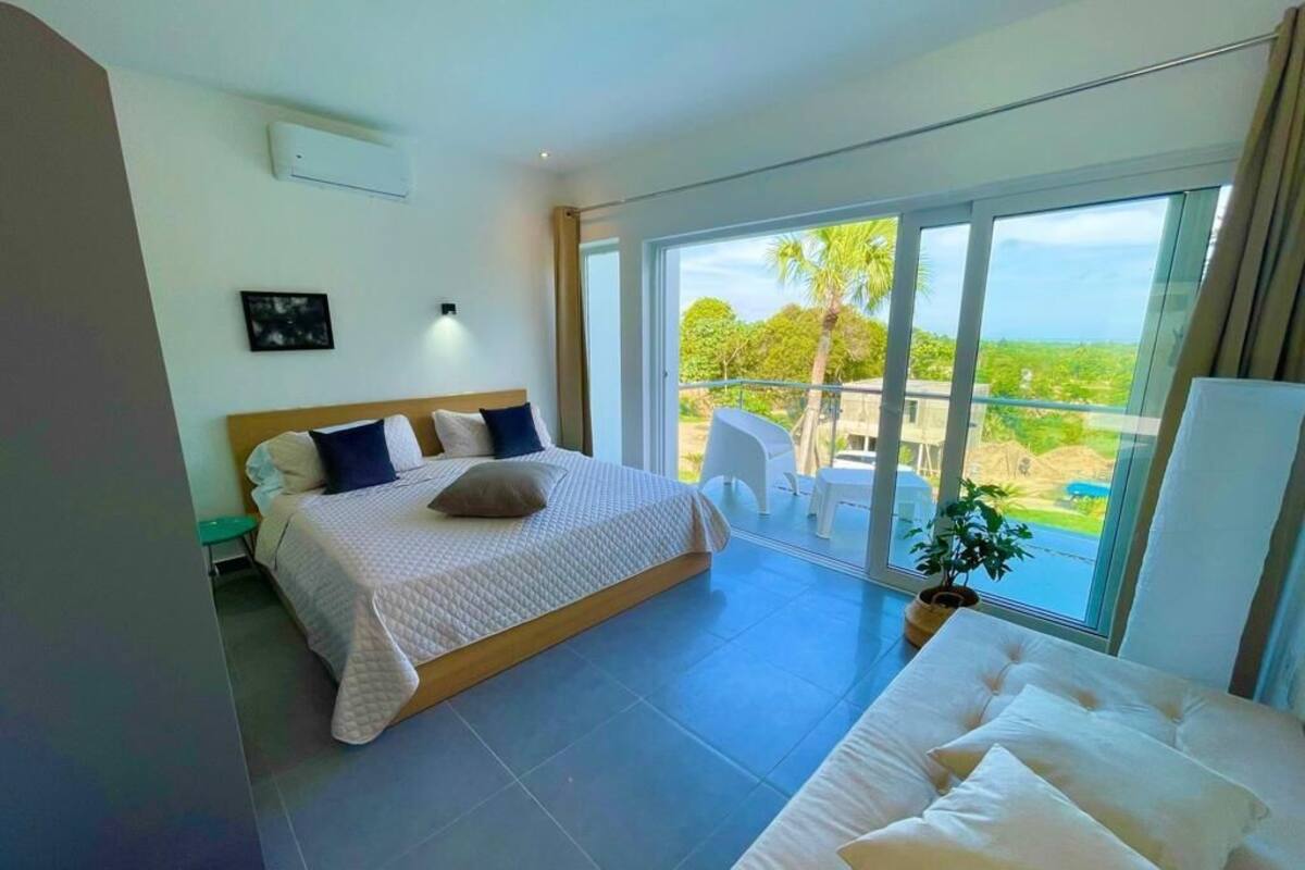 Une chambre moderne avec un grand lit, un canapé et un balcon offrant une belle vue.