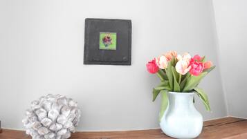 A wooden shelf with a vase of tulips and a decorative object.