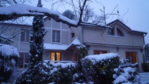A two-story house with a snow-covered garden and a visible entrance. - Chambre d'hôte La Bacotterie (Bois-le-Roi)
